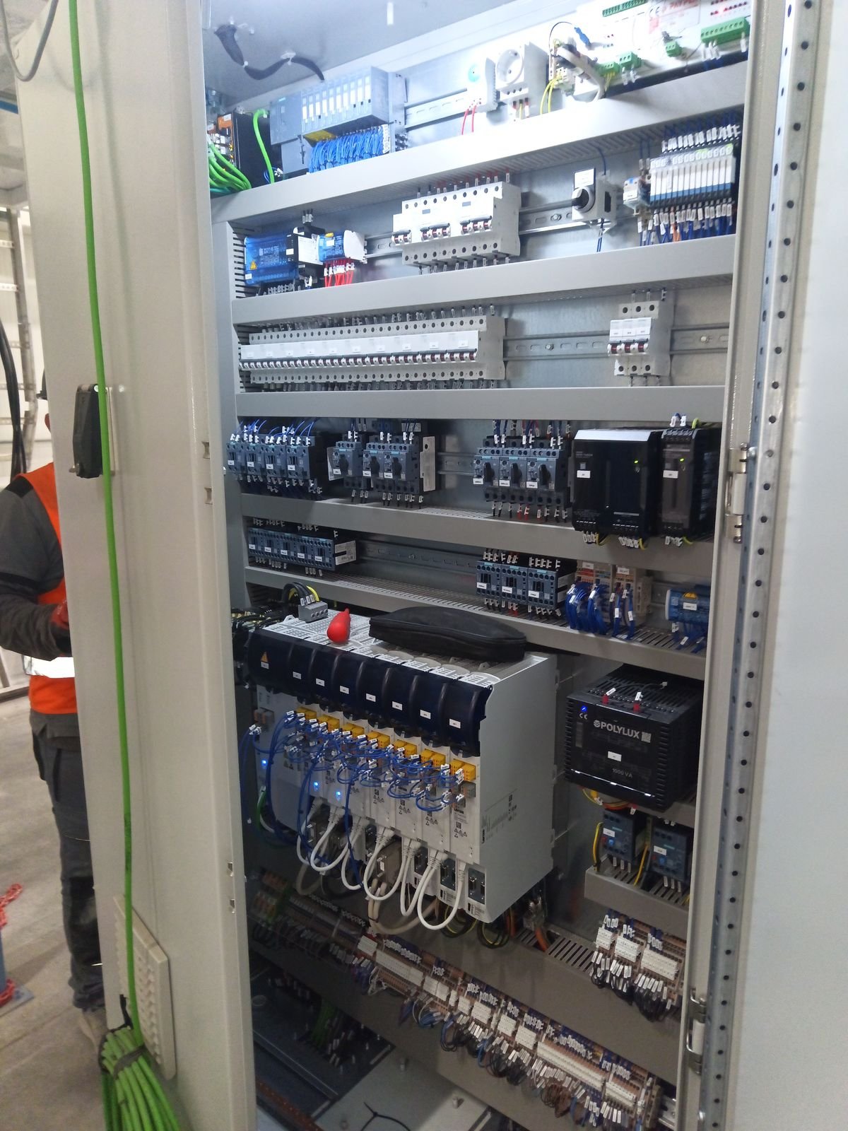 Tablero eléctrico abierto con interruptores, variadores y cableado