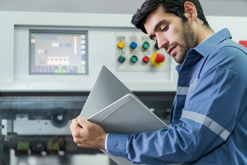 Técnico con carpeta revisando un panel de control